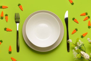 Yeşil arkaplandaki çiçeklerle servis edilen basit şirin Paskalya sofrası