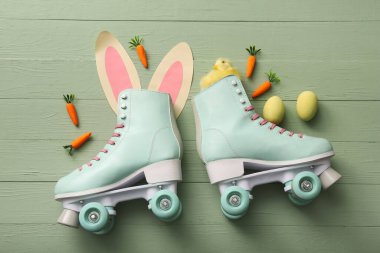 Kağıttan, civcivden, havuçtan ve yeşil ahşap arka planda Paskalya yumurtalarından yapılmış tavşan kulaklı klasik patenler.