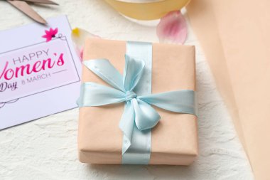 Beyaz arka planda hediye kutusu ve kart. Uluslararası Kadınlar Günü