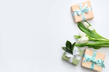 Güzel laleli hediye kutuları ve beyaz arka planda yapraklar. Uluslararası Kadınlar Günü