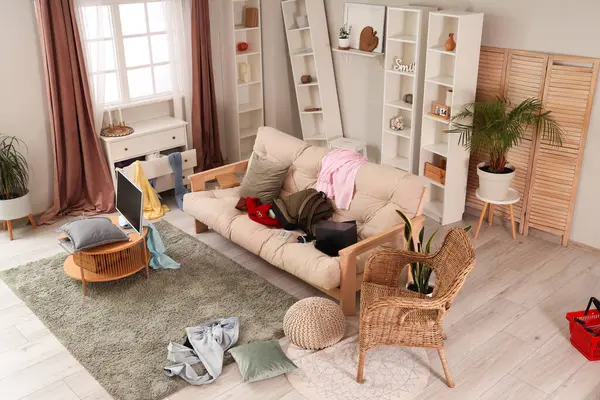 Interior of messy living room with sofa after robbery