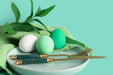 Renkli yumurtalar ve yeşil arka planda dallarla Paskalya için güzel bir sofra.
