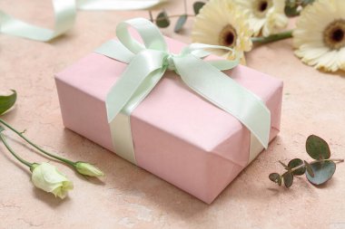 Güzel çiçekli hediye kutusu ve bej arka planda okaliptüs. Uluslararası Kadınlar Günü