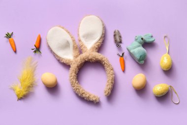 Paskalya yumurtalı tavşan kulakları ve leylak arkaplanlı havuç.
