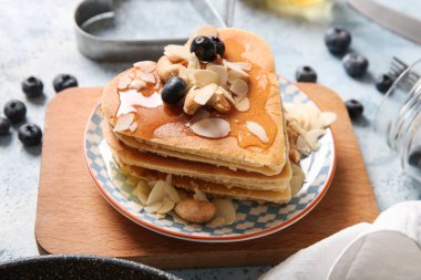 Kalp şeklinde lezzetli gözlemeler, mavi arka planda yabanmersini ve fındık, yakın plan. Sevgililer Günü kutlaması