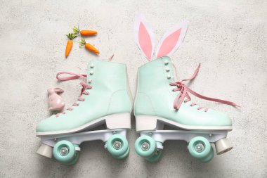 Beyaz arka planda kağıt ve havuçtan yapılmış tavşan kulaklı klasik patenler. Paskalya kutlaması