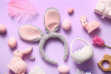 Paskalya kompozisyonu tavşan kulaklı ve leylak arkaplanlı yumurtalar boyalı.