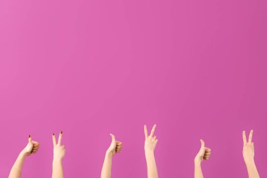 Mor arka planda barış ve baş parmak hareketlerini gösteren kadın elleri