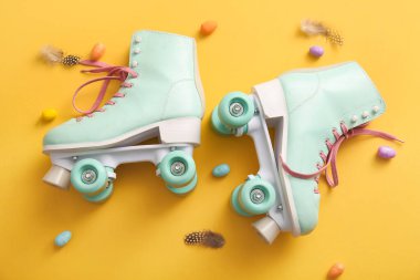 Paskalya yumurtaları ve sarı arka planda tüyleri olan klasik patenler.