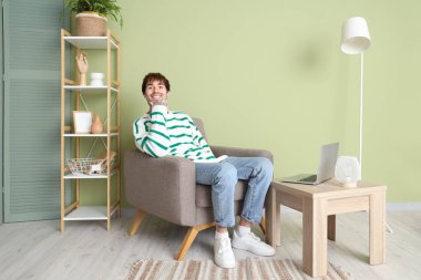 Evdeki yumuşak koltukta dinlenen yakışıklı adam.