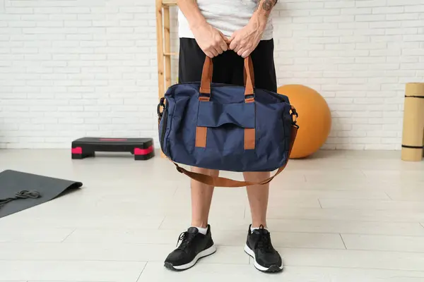 Young man with sports bag  in gym