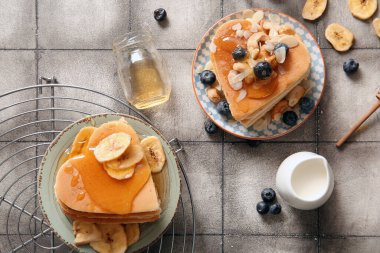 Gri fayanslı arkaplanda kalp şeklinde lezzetli krepler olan kompozisyon. Sevgililer Günü kutlaması
