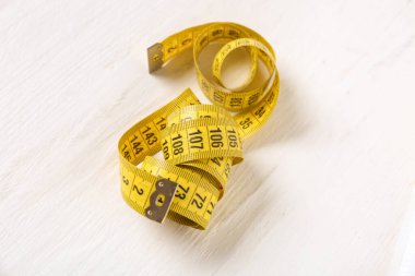 Beyaz ahşap arka planda sarı mezura