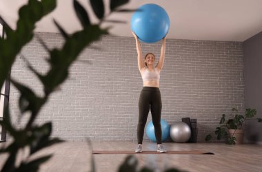 Spor kıyafetleriyle spor salonunda spor salonunda spor yapan güzel genç bir kadın.