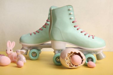 Sarı masada Paskalya yumurtası ve oyuncak tavşanlı klasik patenler.