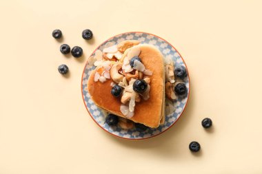 Kalp şeklinde lezzetli krepler, bej arka planda yabanmersini ve fındık. Sevgililer Günü kutlaması