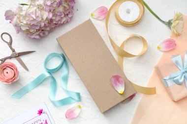 Paket kağıtlı hediye kutuları ve beyaz arka planda güzel çiçekler. Uluslararası Kadınlar Günü