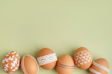 Yeşil arka planda süslü Paskalya yumurtaları olan kompozisyon