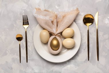 Paskalya yumurtaları, peçete ve çatal bıçak takımlarıyla dolu güzel bir masa.