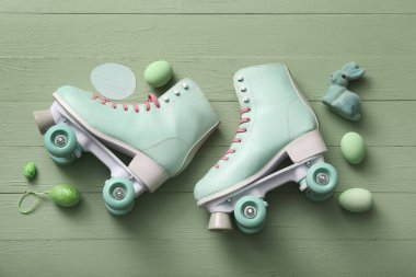 Paskalya yumurtaları ve yeşil ahşap arka planda oyuncak tavşanlı klasik patenler.