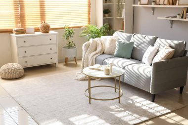 Rahat kanepesi ve masası olan modern oturma odasının içinde.