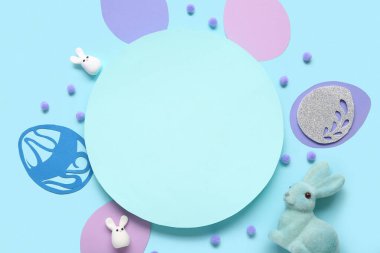 Paskalya tavşanı, kağıt yumurta ve mavi arka planda boş kart. Yakın çekim.