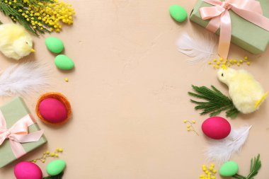 Paskalya yumurtaları, hediyeler, tavuklar ve bej arka planda mimozadan yapılmış çerçeve