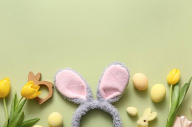 Paskalya yumurtaları ve yeşil arka planda lale çiçekleri olan tavşan kulakları.