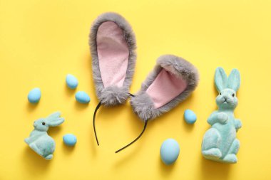 Sarı arka planda Paskalya yumurtası olan tavşan kulaklı.