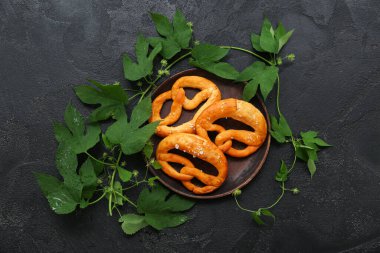 Yumuşak simit tabağı ve siyah zemin üzerinde hop yaprakları