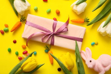 Hediye kutulu lale çiçekleri ve sarı arka planda Paskalya tavşanı.