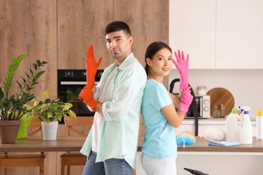 Mutfağı temizleyen lastik eldivenli genç çift.