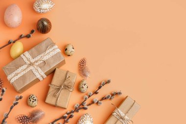 Turuncu arka planda Paskalya hediyeleri, yumurtalar ve söğüt dalları