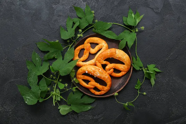 Yumuşak simit tabağı ve siyah zemin üzerinde hop yaprakları