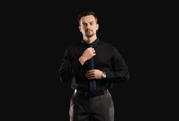 Schöner Geschäftsmann Befestigt Krawatte Auf Dunklem Hintergrund — Stockfoto