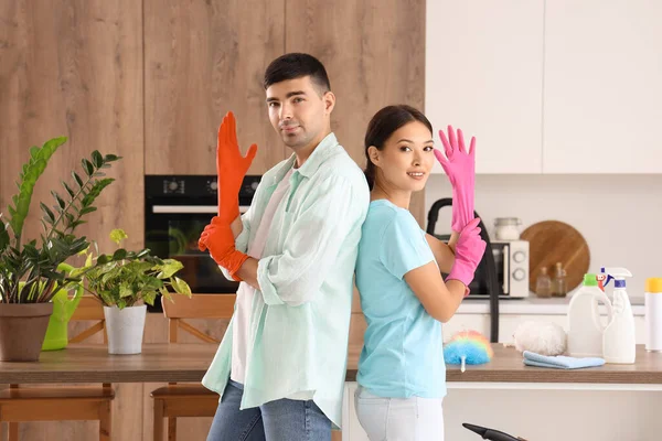 Mutfağı temizleyen lastik eldivenli genç çift.