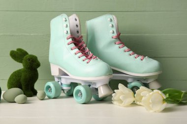 Güzel laleli klasik patenler, oyuncak tavşancık ve beyaz ahşap masada Paskalya yumurtaları.