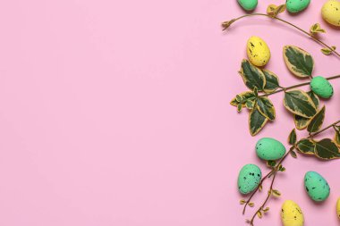 Pembe arka planda yaprakları olan Paskalya yumurtaları