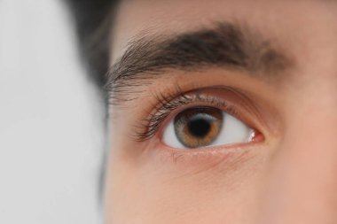 Mavi arka planda kahverengi gözlü genç adam, yakın plan. Glaucoma farkındalık ayı
