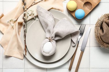 Paskalya için çok güzel bir masa. Beyaz fayanslı yumurta, çiçek ve söğüt dalları.