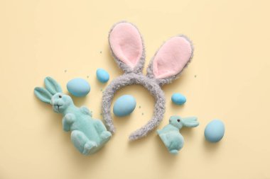Paskalya yumurtaları ve bej arka planda tavşancıklar olan tavşan kulakları