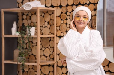 Banyoda göz altı bantları olan genç bir kadın.