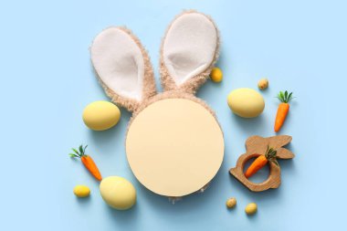 Paskalya yumurtası, havuç ve mavi arka planda boş tebrik kartı olan tavşan kulakları.