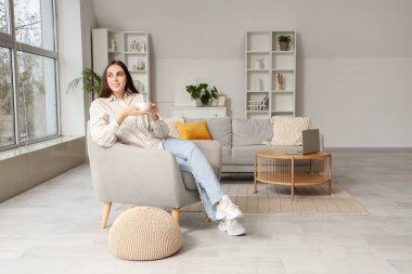 Güzel bir kadınla evde koltukta oturup çay