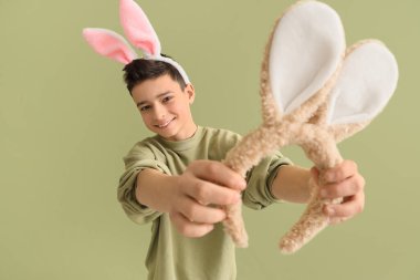 Yeşil arka planda tavşan kulaklı küçük çocuk