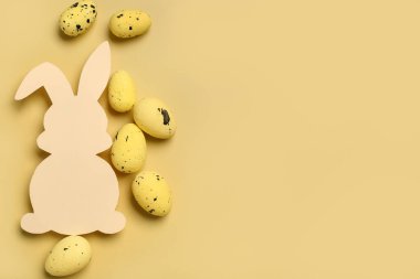 Sarı arka planda Paskalya yumurtalı kağıttan tavşan.