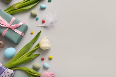 Lale çiçekli Paskalya yumurtaları ve gri arka planda hediye kutusu.