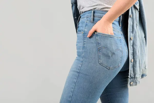 Gri arka planda şık kotlu güzel kadın, yakın plan.