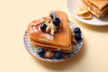 Kalp şeklinde lezzetli gözlemeler, bej arka planda yabanmersini ve fındık, yakın plan. Sevgililer Günü kutlaması