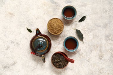 Sıcak demlenmiş çaydanlık, bir fincan portakal çayı ve beyaz arka planda pudralanmış kibrit.